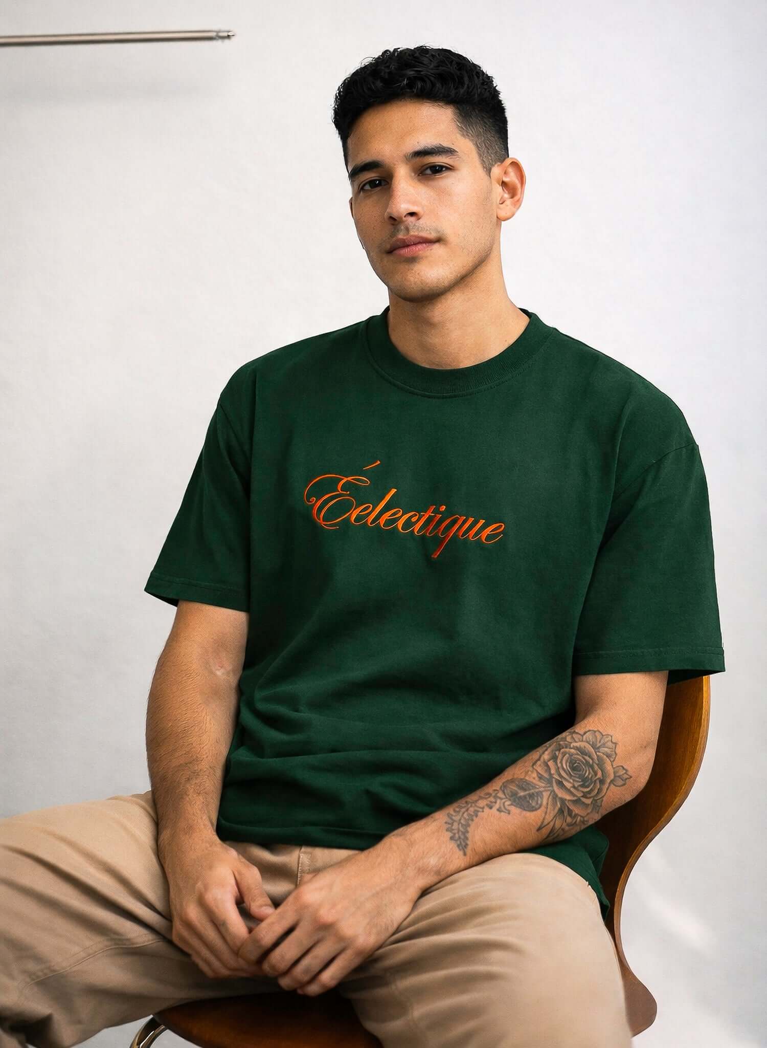 Script logo embroidered cotton t-shirt in emerald worn by a man, featuring the Éclectique logo in orange.