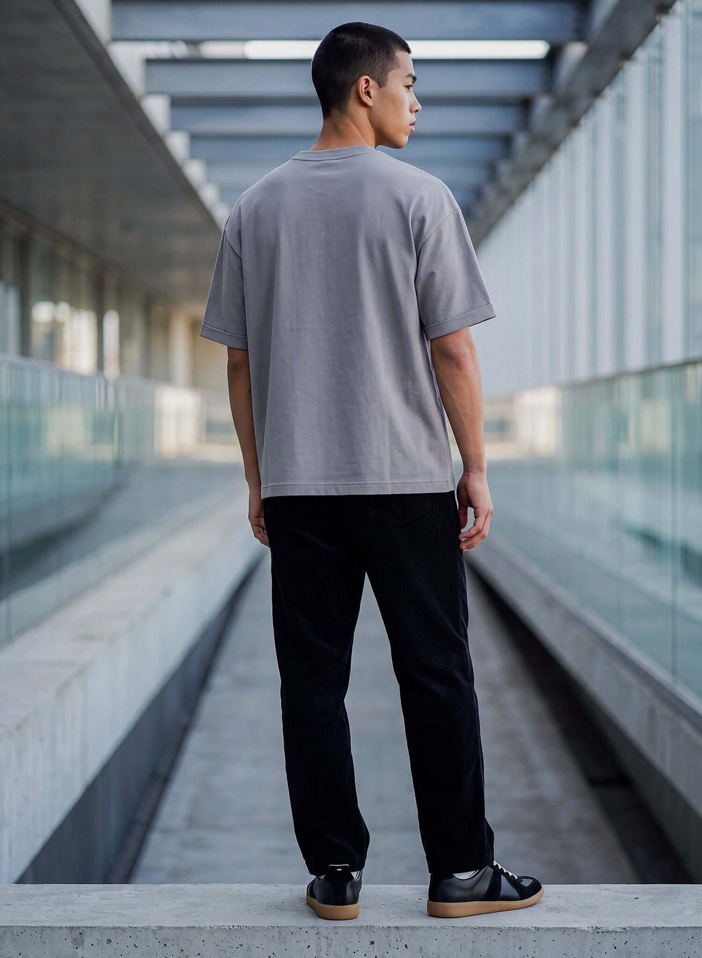 Men's Dolphin Grey Cotton T-shirt displayed on a model from the back, showcasing a relaxed fit and clean neckline.