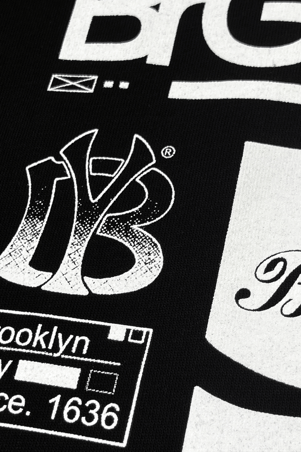 Close-up of printed artwork on Brooklyn graphic t-shirt featuring bold black and white designs.