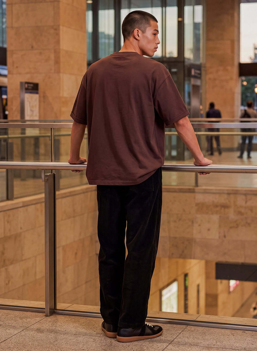 Men's Chocolate Brown Cotton T-shirt worn by a man standing indoors, showcasing relaxed fit and simple style.