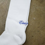 White logo socks featuring Éclectique’s blue script logo on a soft white cotton fabric.