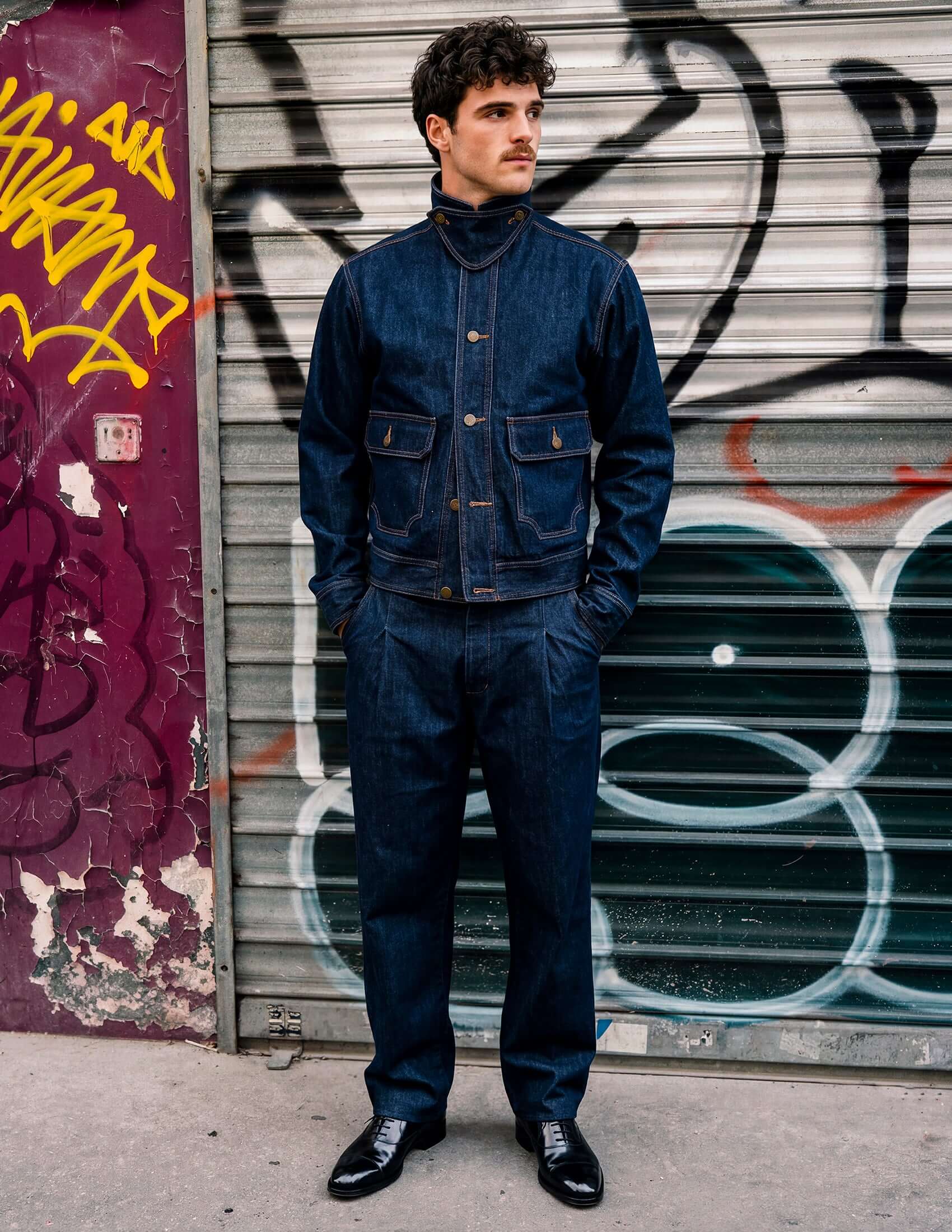 Kura Indigo Jacket styled with matching pants, featuring deep indigo wash and unique throat latch detail.