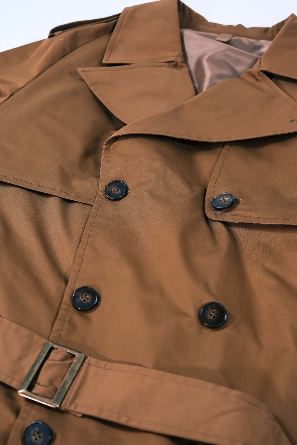 Men's camel trench coat flat lay showcasing its relaxed oversized fit and elegant camel color.