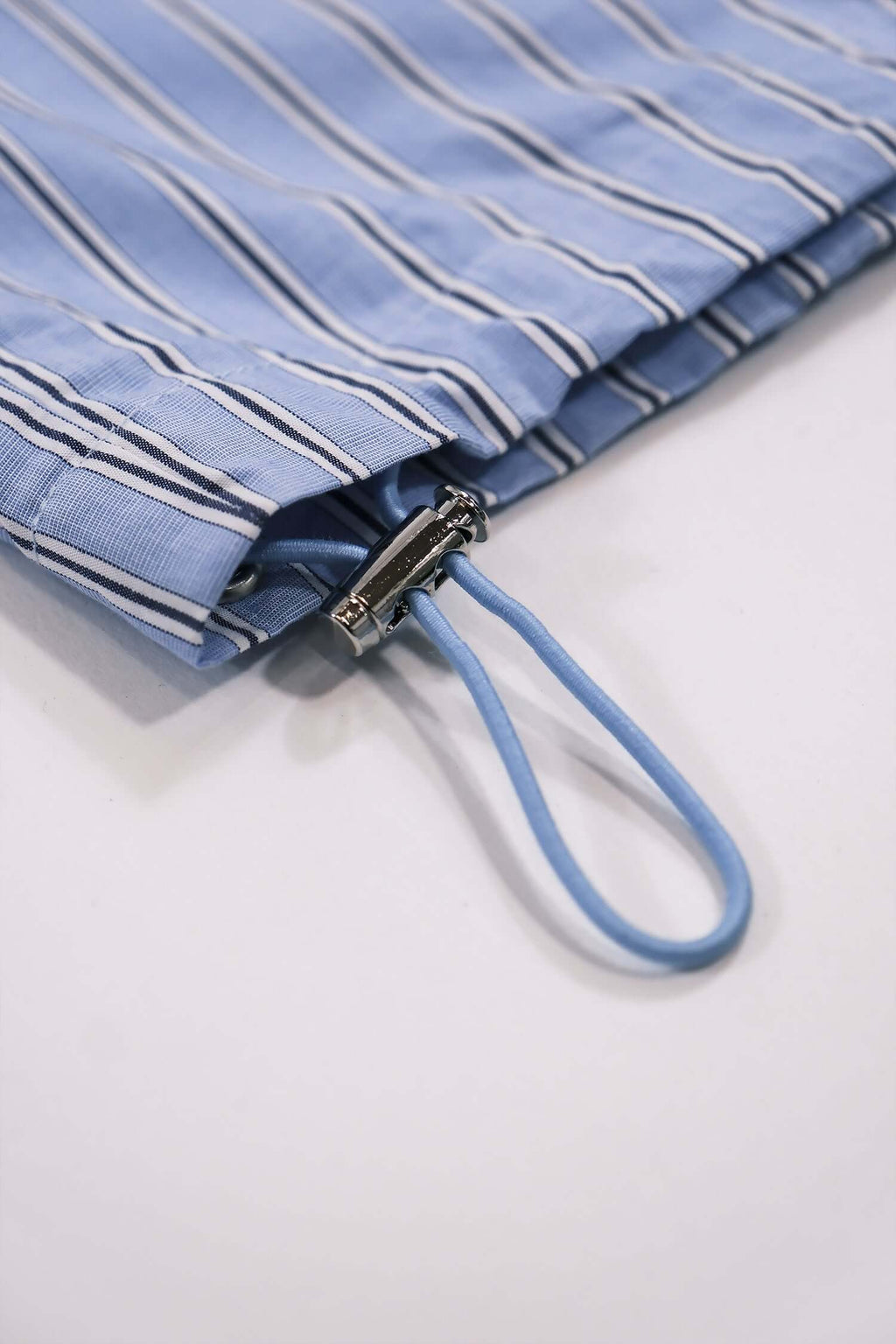Close-up of men's striped casual pants featuring a blue striped pattern and practical drawstring detail.