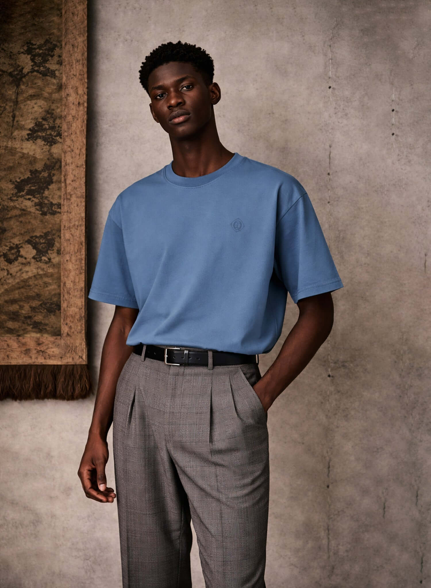 Monogram embroidered cotton t-shirt in blue, featuring embroidered logo on left chest, styled with gray pants.