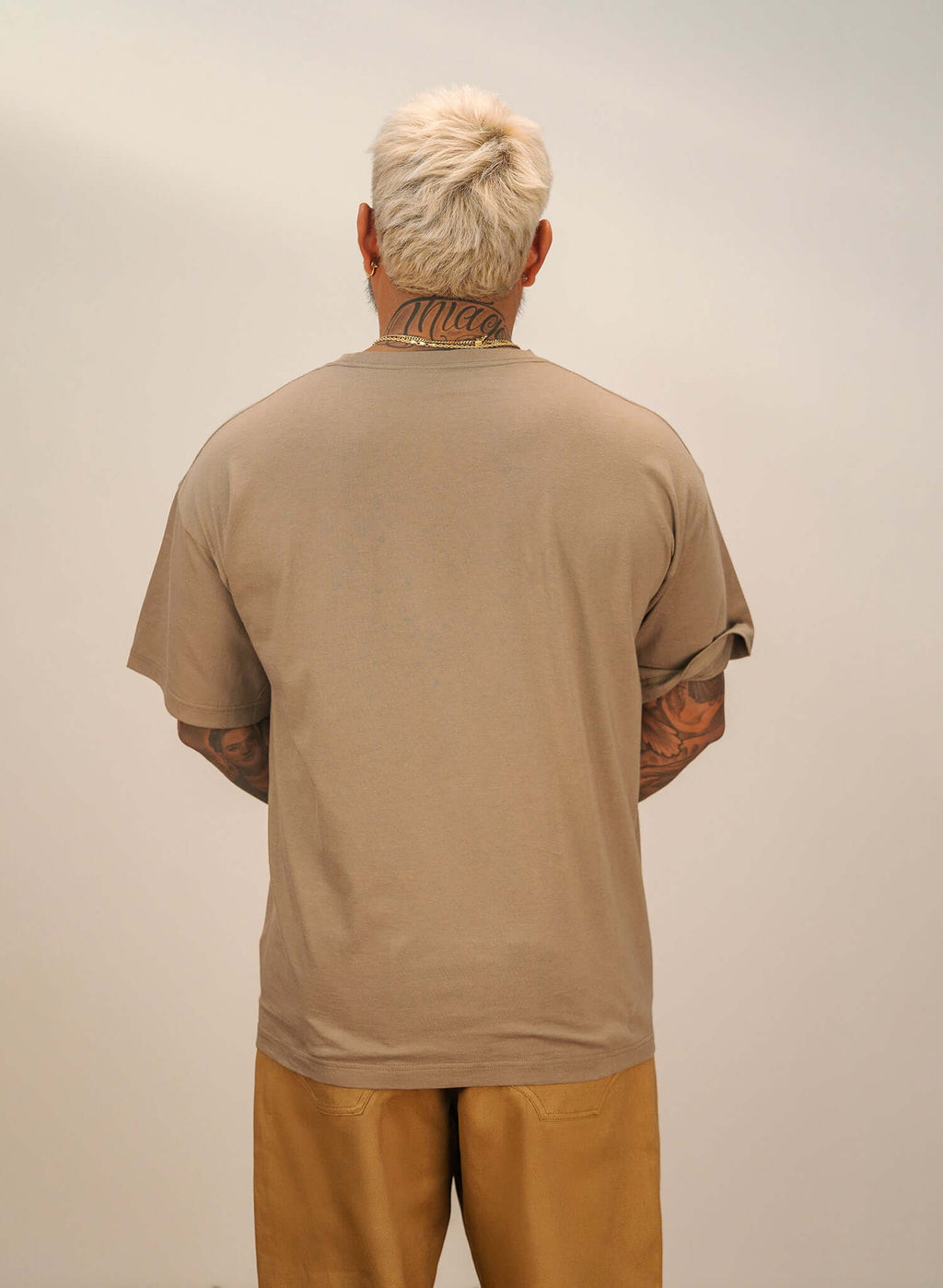 Back view of men's sand cotton t-shirt, showcasing relaxed fit and warm sand tone.