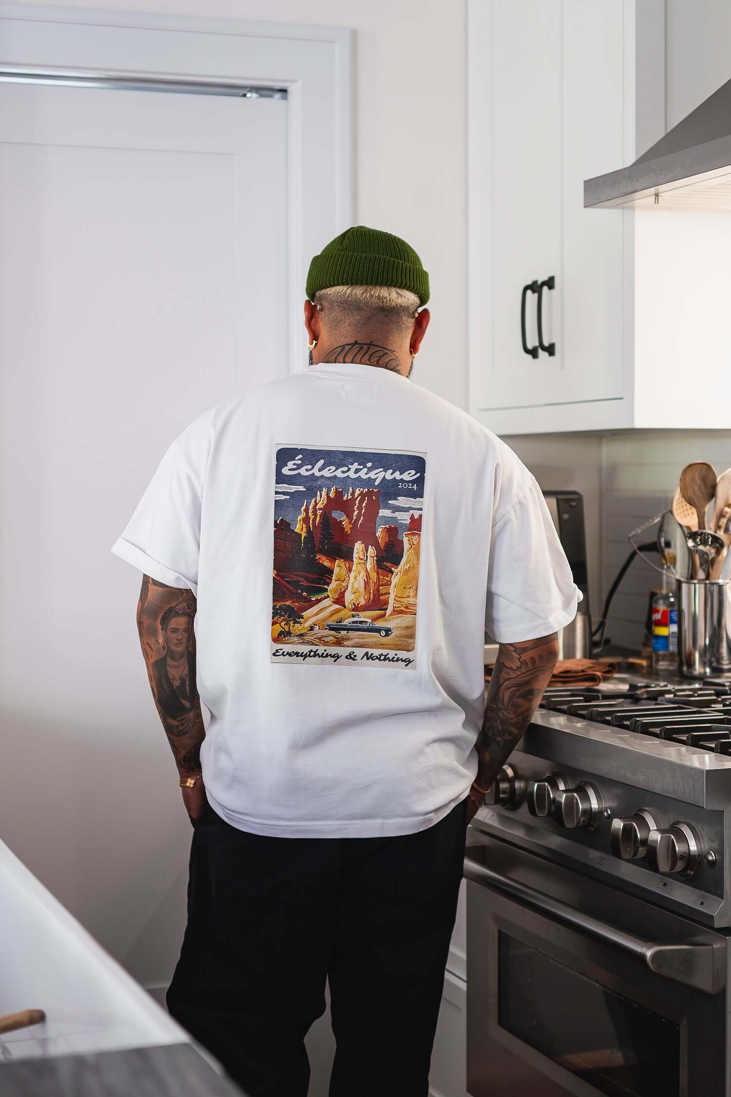 Man wearing a Sedona graphic T-shirt with a poster illustration of desert landscapes on the back.