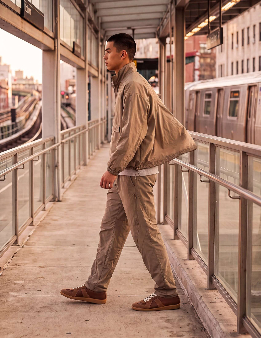 Man wearing Waypoint Lightweight Anorak in clay color, walking in an urban setting, showcasing modern style.