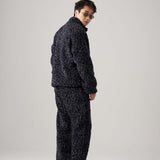 Man wearing black leopard fleece pants and matching jacket, showcasing a stylish and relaxed outfit.
