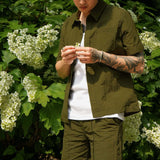 Men's casual shorts in olive green, featuring a slim fit and lightweight design, paired with a matching shirt.