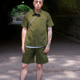 Designer Short sleeve casual shirt displayed on a model in an outdoor setting, showcasing a stylish olive green design.