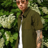 Designer Short sleeve casual shirt in olive worn by a model among white flowers, showcasing refined style and comfort.