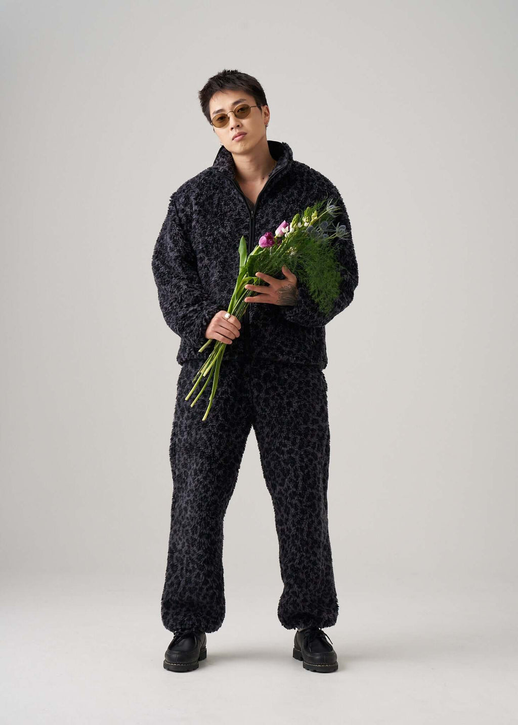 Model wearing Éclectique black leopard fleece jacket and pants