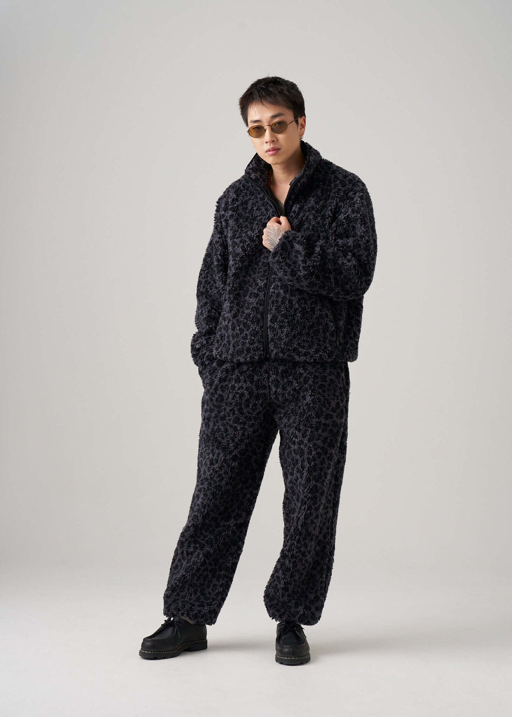 Model wearing Éclectique black leopard fleece jacket in studio