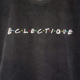 Classic Friends logo t-shirt displayed with the print 'ÉCLECTIQUE' in colorful letters on a black acid-wash T-shirt.