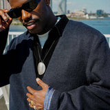Man wearing Kanso Collarless Long Coat and sunglasses with a stylish city backdrop.