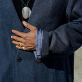 Close-up of a person wearing a Kanso Collarless Long Coat with a detailed view of the sleeve and hand.