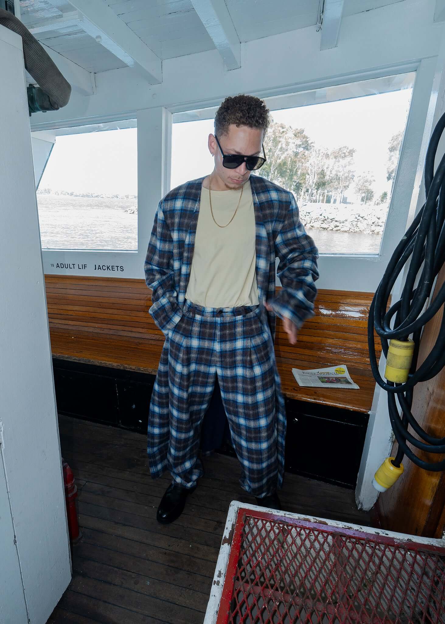 Model wearing a plaid collarless long coat with a matching outfit, showcasing modern street style and elegance.