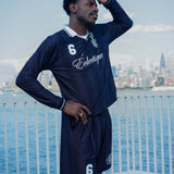 Man wearing Performance soccer shorts and a matching jersey against a city skyline backdrop.