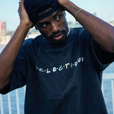 Young man wearing a Seinfeld Vintage logo hat and Eclectique t-shirt by the waterfront.