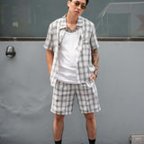 Model wearing monotone plaid shorts with matching shirt, showcasing stylish and casual summer outfit.