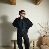 Model wearing Éclectique Italian suede bomber jacket in black with tailored trousers