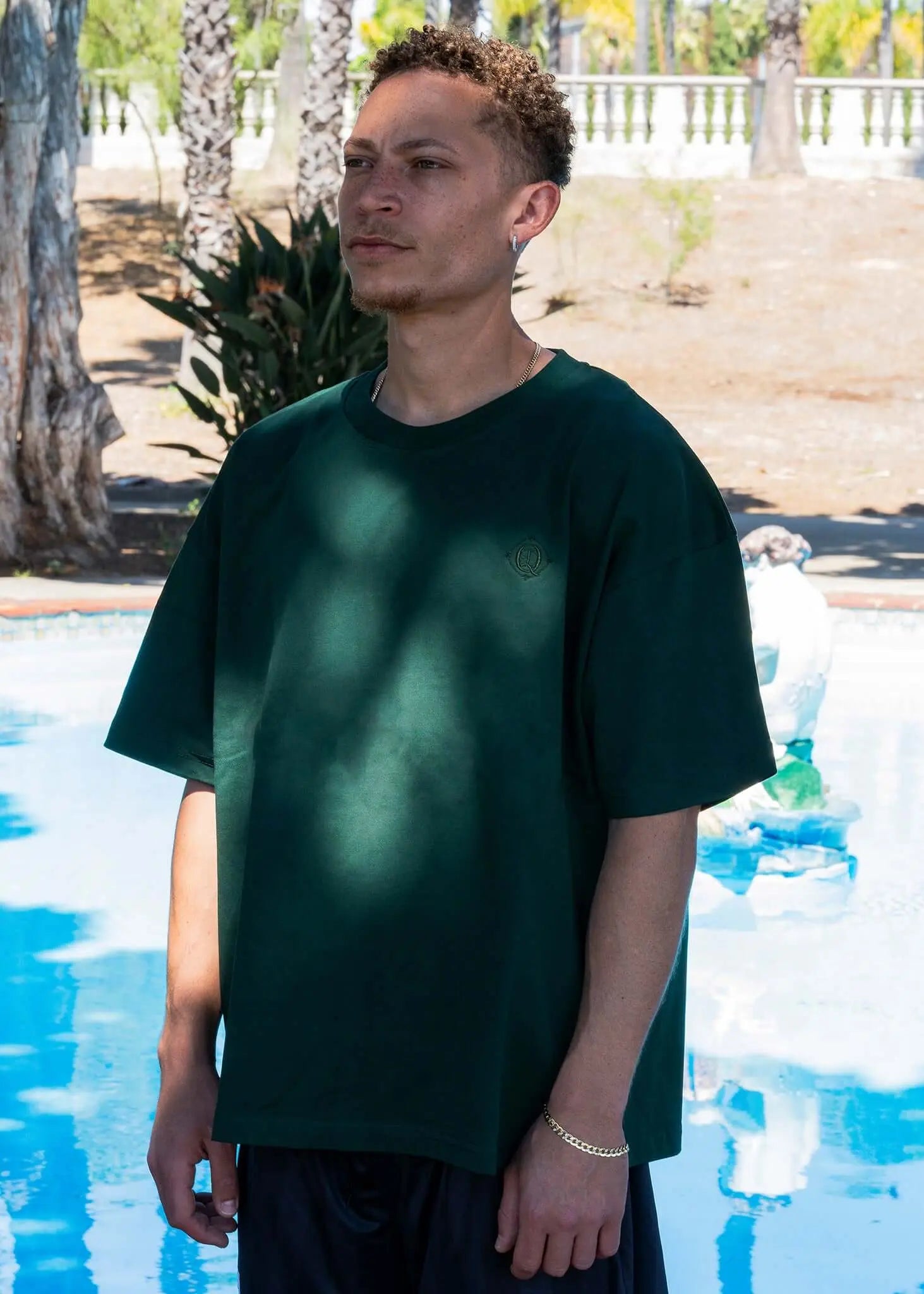 Monogram embroidered cotton t-shirt in emerald worn by a model, showcasing the clean silhouette and embroidered logo.