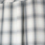 Close-up of the fabric pattern of the monotone plaid button-up shirt in soft cotton with a modern aesthetic.