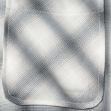 Close-up of the pocket on a monotone plaid button-up shirt showcasing its texture and design details.