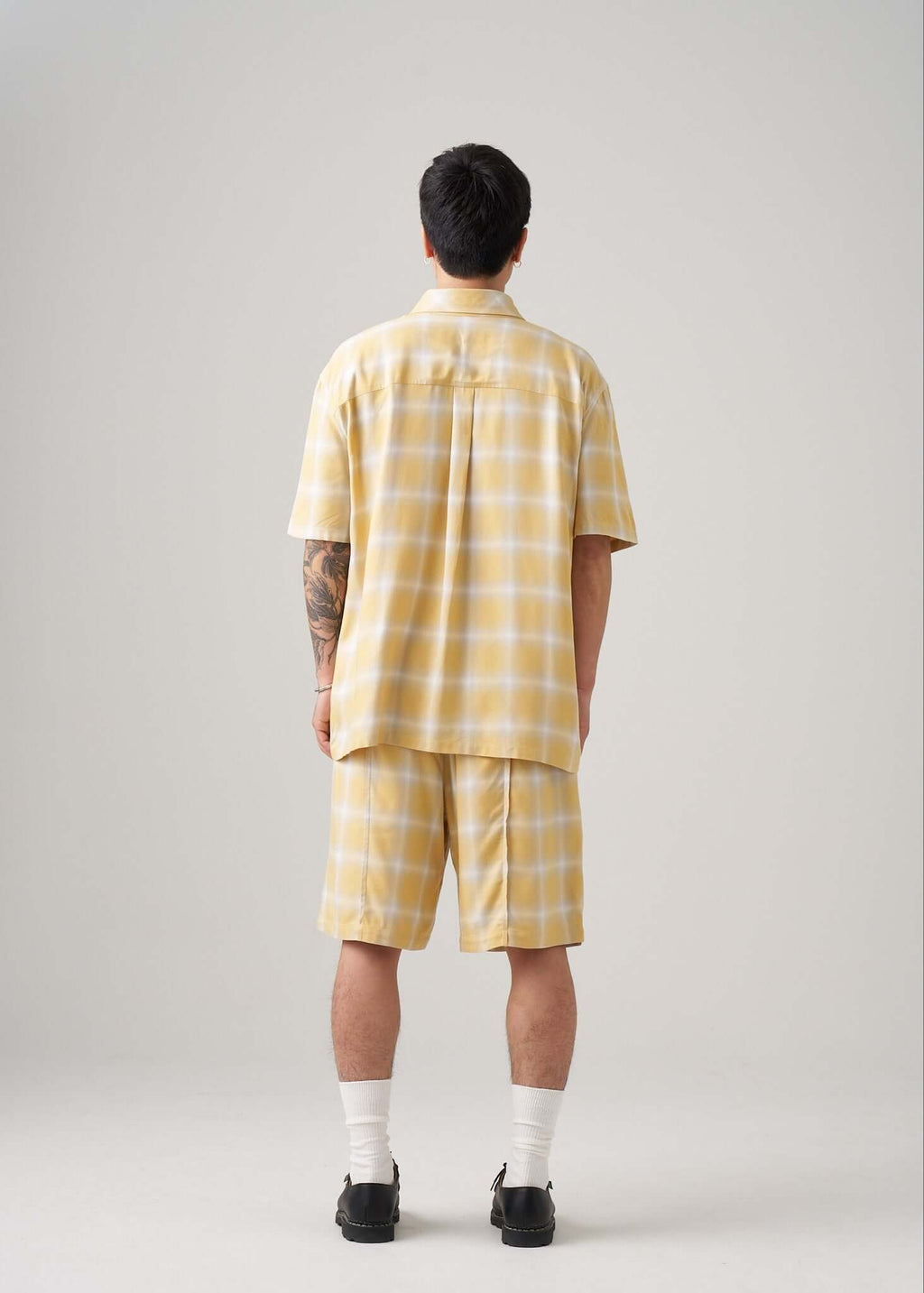 Man wearing an ombre plaid shirt in yellow, showcasing the back view and its comfortable fit.