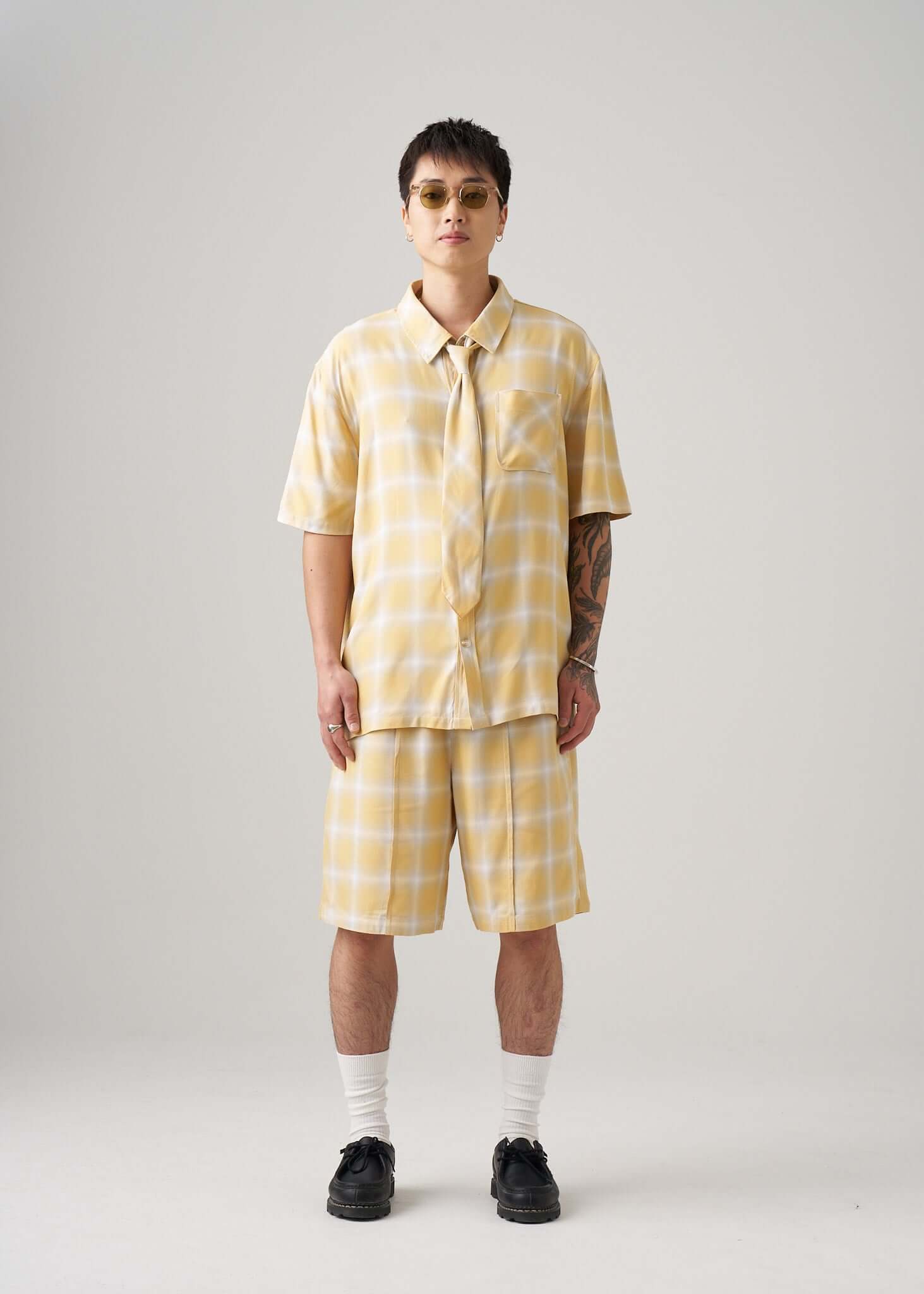 Ombre plaid shirt in yellow styled with matching shorts, showcasing a trendy summer outfit.