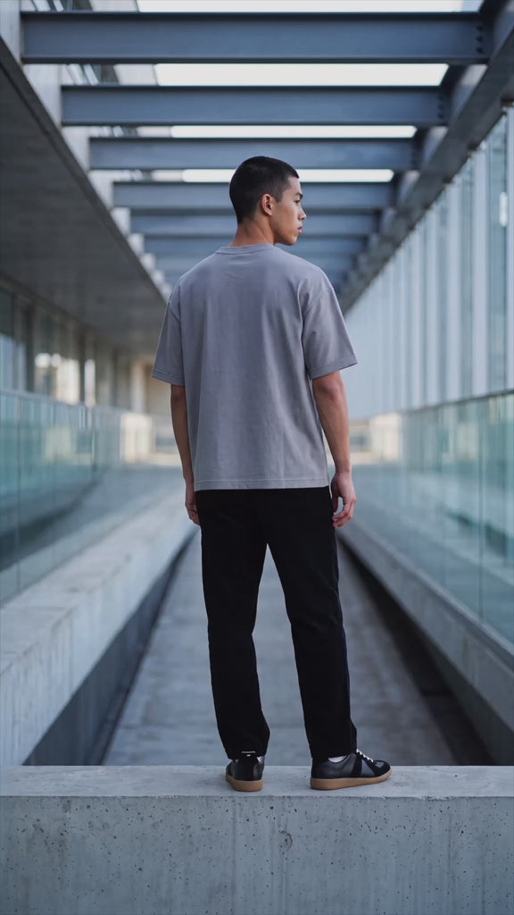Éclectique Dolphin Grey Essential cotton T-shirt on model, showing relaxed fit and woven hem label.