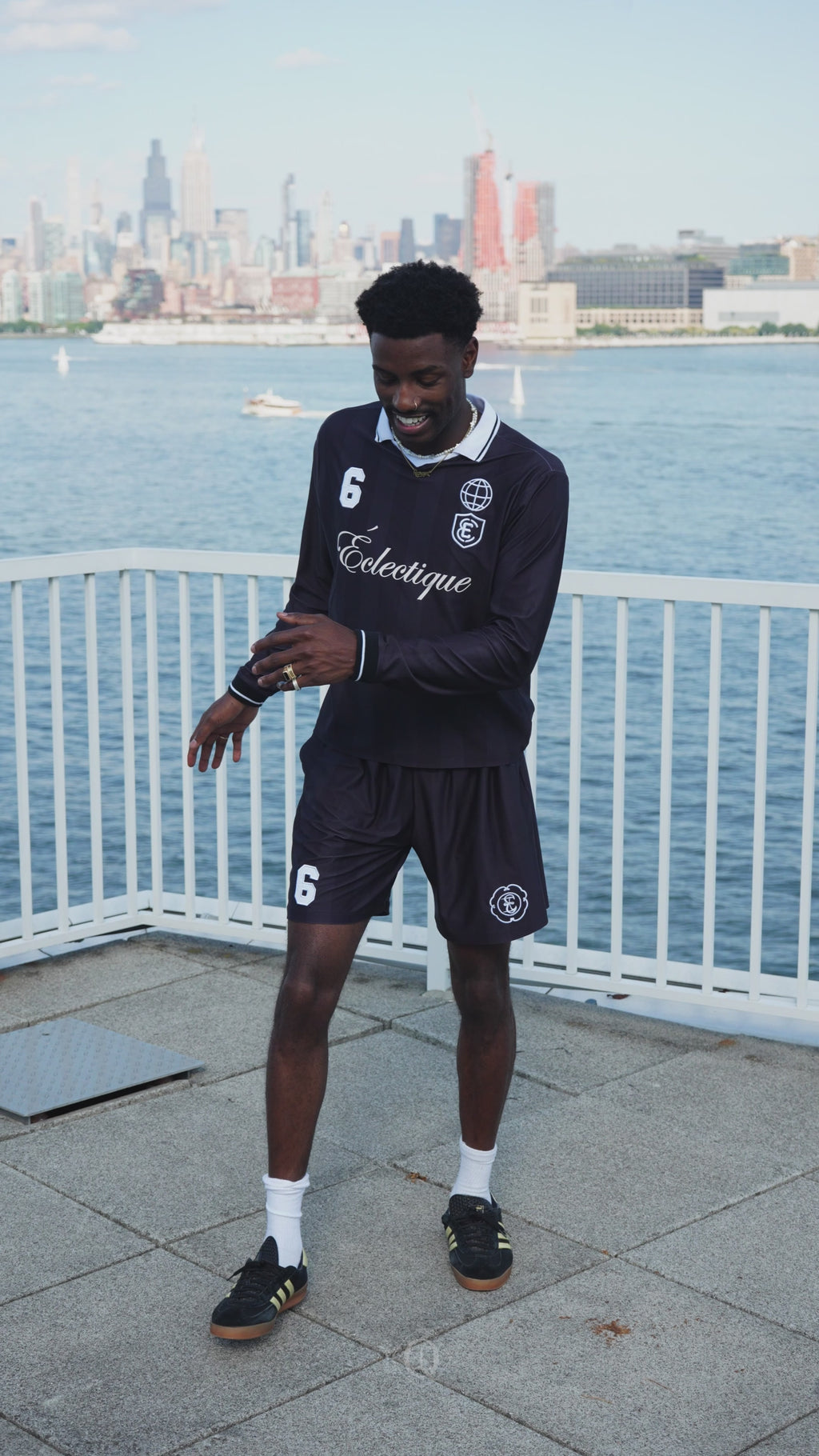 Model in motion wearing performance soccer shorts by Éclectique near waterfront with city skyline in New York