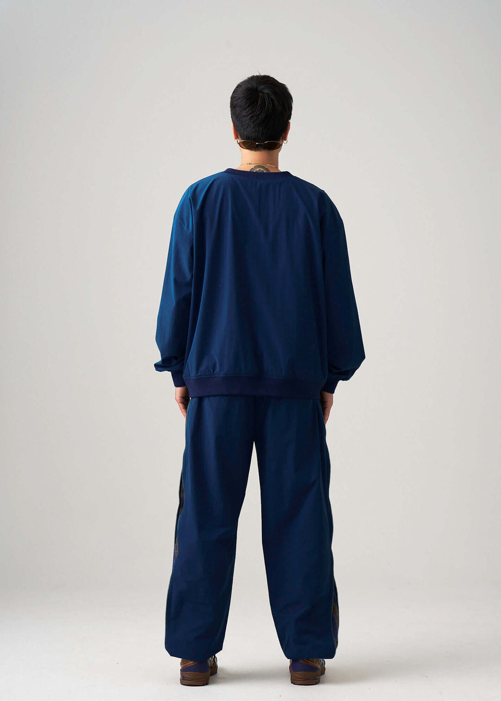 Back view of the reversible windbreaker jacket in navy lightweight fabric on model