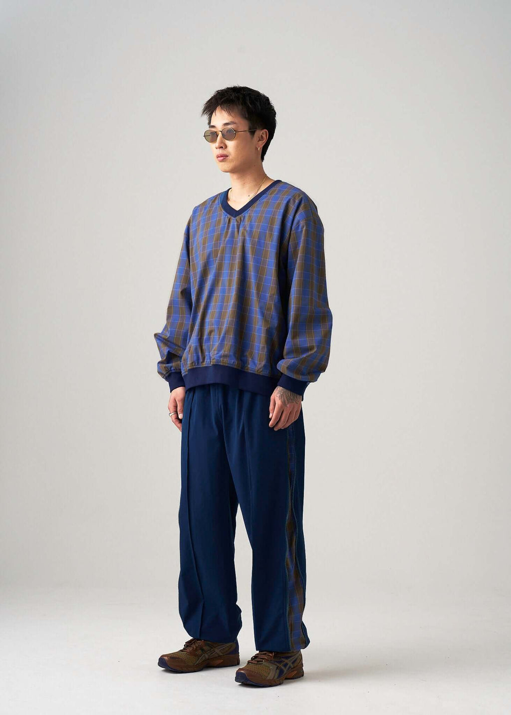 Reversible windbreaker jacket styled in navy with a modern loose fit, model posed at an angle