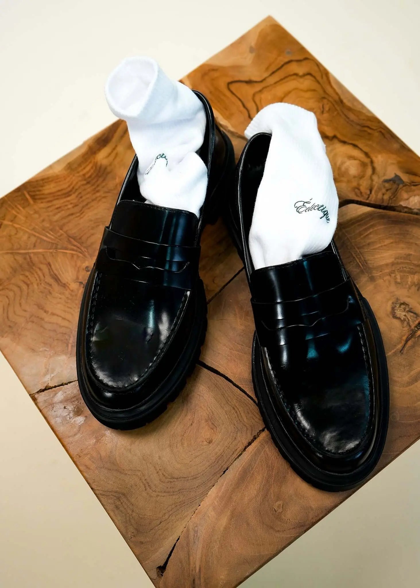 White logo socks with green script logo inside black loafers
